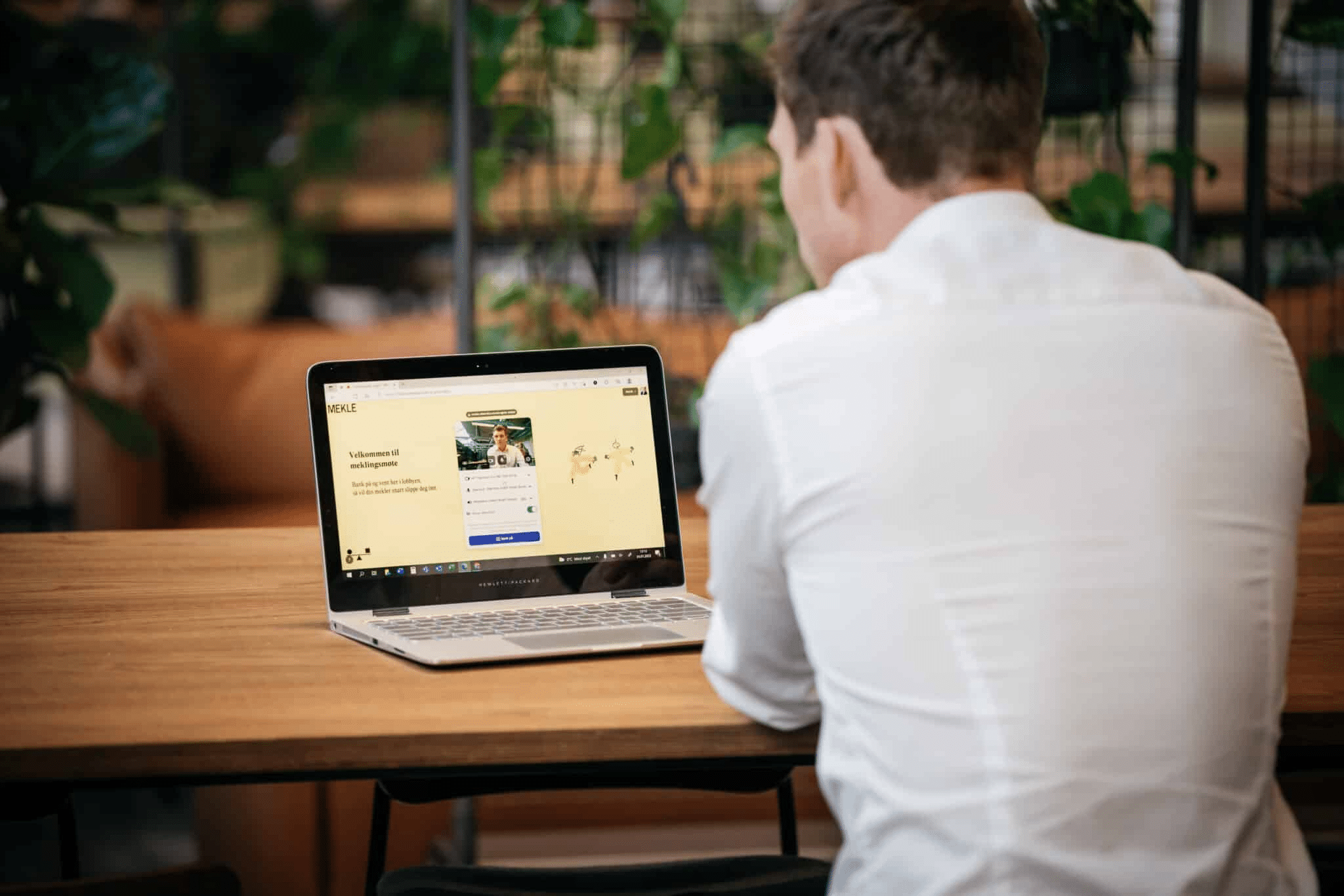 En mann sitter med ryggen til og skjermen viser at han sitter i et digitalt venterom i forkant av et meklingsmøte med MEKLE